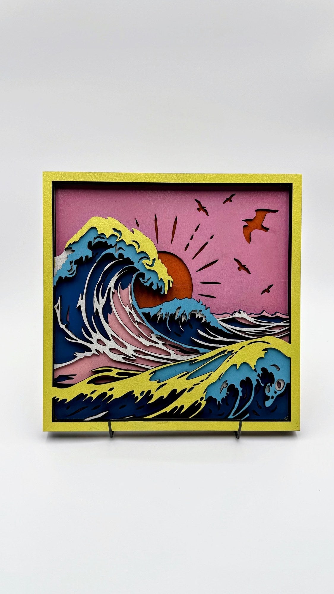 Layered wood sunset ocean wave wall art with yellow frame and coastal colors by Shoreline Custom Creations