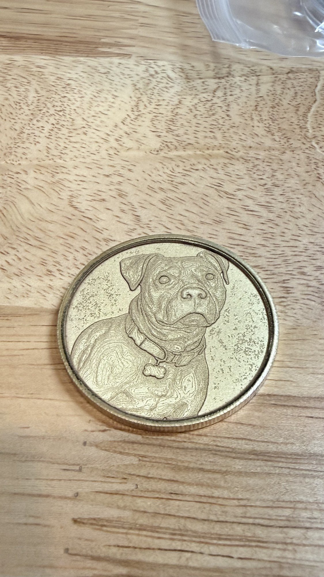 Custom laser-engraved pet portrait keepsake coin featuring a dog, on natural wood by Shoreline Custom Creations
